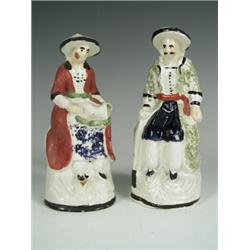 Two 19th century Yorkshire pottery figures of an oriental man and woman, (one unglazed, both w...