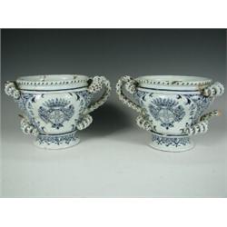 A pair of 18th century Delft style vases, each with spiral and twist handles and crests to eac...