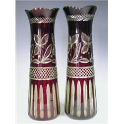 A pair of late 19th century Bohemian glass vases with green tinted glass encased in ruby glass...