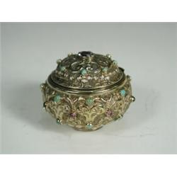 A small gilt metal box cast with floral scrolling decoration and inset with paste, enamels and...