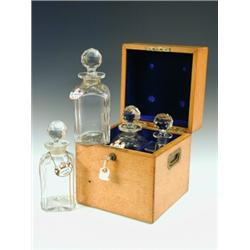 A mid 19th century oak tantalus box with four decanters (one matched, one damaged), in a velve...
