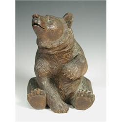 A late 19th century black forest carved bear, with a hinged head and compartment, 22cm high<br...