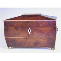 A George III yew wood veneered tea caddy with boxwood stringing supported on brass ball feet,...