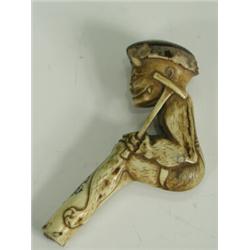 An ivory parasol handle carved in the form of a devil holding a crutch and a begging bowl (som...