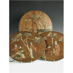 Three oriental hardwood plaques, each inlaid with hardstones, representing figures in a garden...
