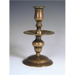 A 17th century brass candlestick with trumpet shaped base, with wide central drip pan, 22cm<br...