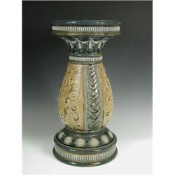 A Royal Doulton stoneware jardiniFre stand of baluster shape decorated with panels of scrollin...