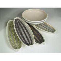 Four Poole pottery freeform cucumber dishes, each with different decoration, 32cm long togethe...