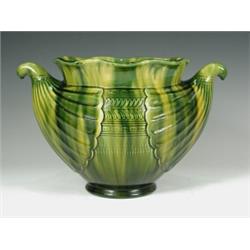 An Ault green glazed jardiniFre, designed by Christopher Dresser, with two conch shaped moulde...