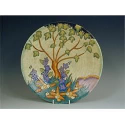 A Fieldings Crown Devon charger, with tube lined tree, flower and leaf decoration, printed and...