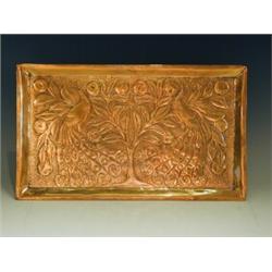 A Glasgow School copper tray, with repousse and hammered peacocks within pear trees, 40.5 x 24...