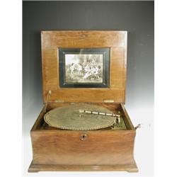 A 15 1/2 inch table top polyphon, the walnut case with an inlaid lid together with 28 discs<br...