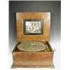 Image 1 : A 15 1/2 inch table top polyphon, the walnut case with an inlaid lid together with 28 discs<br...