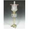 Image 1 : A Victorian oil lamp, with a tinted shade above a moulded glass reservoir supported upon a bra...