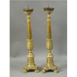 A pair of antique continental gilt wood candlesticks with carved decoration on triform bases a...