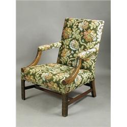 A Chippendale style mahogany library chair with blind fret carving and floral upholstery Es...