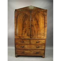 An early Victorian mahogany linen press with an architectural cornice over two panelled doors...