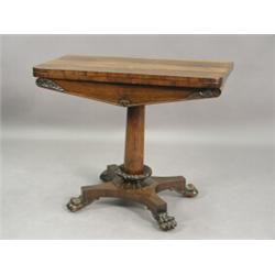 A late Regency rosewood fold over card table with a circular baize lining on a tapering column...