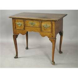 An oak lowboy with three frieze drawers on shaped legs and pointed pad feet, 80cm wide Est....