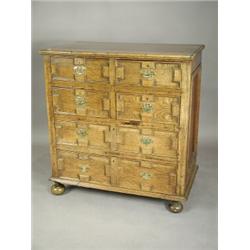 An oak chest of drawers having two short and three long drawers with geometric mouldings withi...