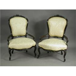 A pair of stained walnut open armchairs, with carved top rails on cabriole legs, with castors<...