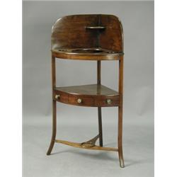 A George III mahogany corner washstand with a single drawer and united by a 'T' shaped stretch...