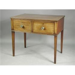 A Sheraton mahogany serving table, the reeded top above one short and one dummy drawer, with a...