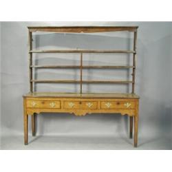An early 19th century oak dresser with an associated plate rack over three drawers and square...