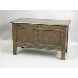 A 17th century oak coffer, with a moulded top over a carved frieze and stiles, and lozenge car...