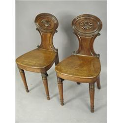 A pair of 19th century mahogany hall chairs, the shaped backs with paterae decoration, on turn...