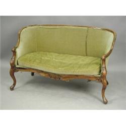 A mid Victorian walnut settee with a serpentine front, carved arms and cabriole legs, 145cm wi...