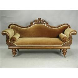 A Victorian carved mahogany scroll end settee, with a shaped back, carved with flowerheads and...