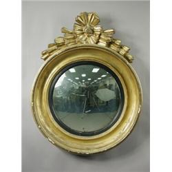A Regency convex wall mirror, the moulded gilt frame with a carved wood crest, 70cm diameter<b...