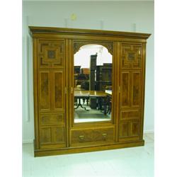 An Arts & Crafts design triple door wardrobe in walnut with burrwood panels, and Bramah locks,...