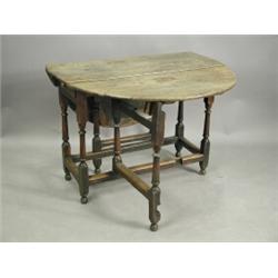 A 17th century oak oval top gateleg table, with a single frieze drawer on turned baluster legs...