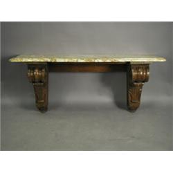 A heavy oak pier table with carved scrolled and acanthus leaf ends supporting a shaped marble...