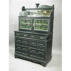 An 'Aesthetic' ebonised side cabinet, with two lead glazed doors over a pair of drawers and mo...