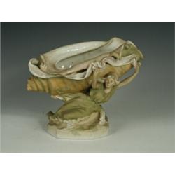 A Royal Dux group of a reclining maiden supporting a shell, raised pink triangle mark and impress...