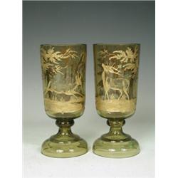 A pair of green glass Bohemian goblets with a wheel cut and gilded Stag, doe and woodland decorat...