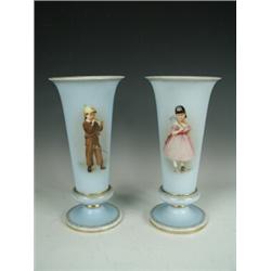 A pair of late 19th century French glass vases, decorated with a Bavarian boy and girl in costume...