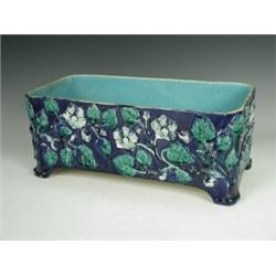 A Victorian majolica planter with leaf moulded floral decoration throughout against a blue ground...