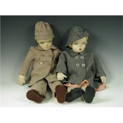 Two cloth and fabric dolls, both dressed in coats, one with a dress the other with matching trous...