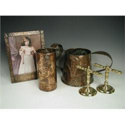 An Arts & Crafts copper jug with stylised tree designs, a copper picture frame, two brass fire ir...