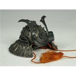 A Japanese white metal helmet box in the form of a Kabuto with Fukurin, circa 1900 Est. 600/800...