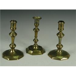 A pair of 18th century brass candlesticks with octagonal domed bases, and a similar single stick...