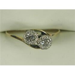 A diamond crossover ring illusion set in white with two stones of approx 0.15ct each to an 18ct y...