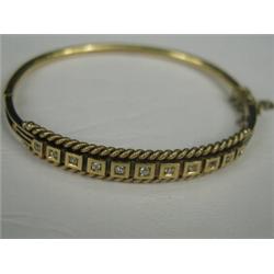 A yellow metal (tests gold) Victorian hinged bangle set with eleven graduated old cut diamonds (t...