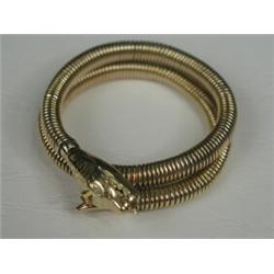A yellow metal (tests gold) snake bangle with old-cut diamond set eyes and an emerald to its head...