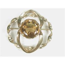 A large yellow metal (tests 9ct) brooch set with a citrine of approx 28mm in diameter, overall di...