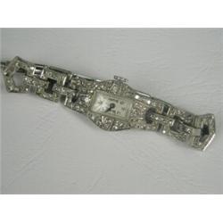 A platinum and diamond cocktail watch with a silver bracelet and safety chain Est. 1000/1500...